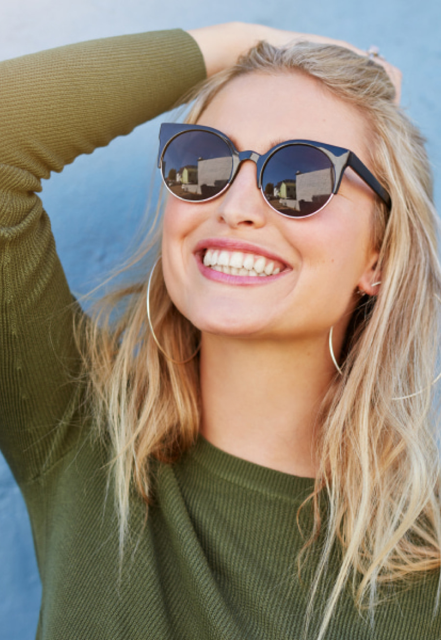 A girl wearing sun glasses is smiling